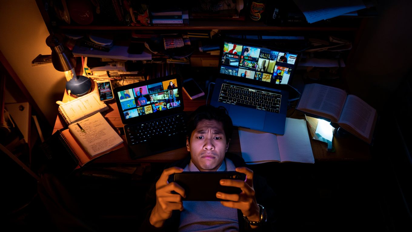 Человек с телефоном в руках вокруг мониторов